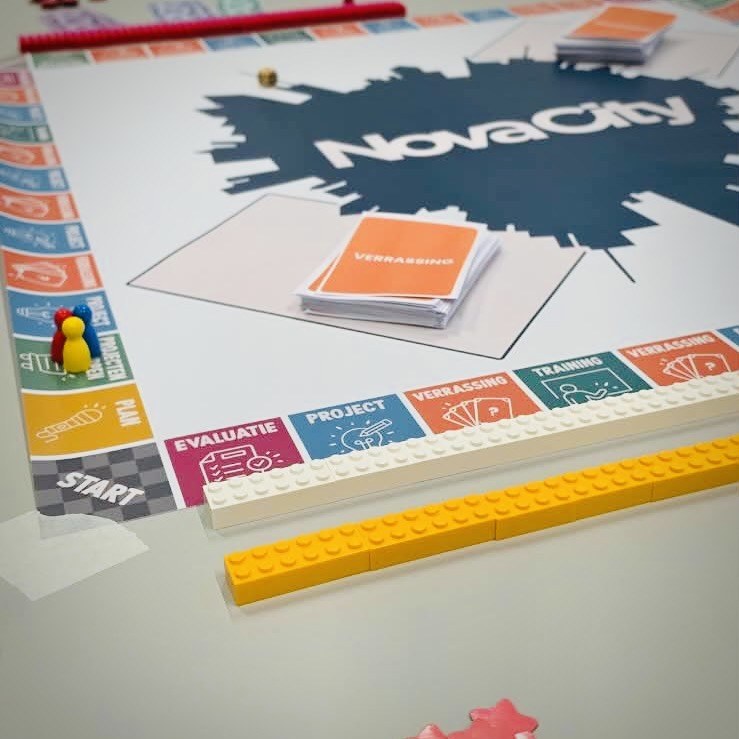 Gros plan sur le plateau Novacity : cases Plan, Projet, Surprise, pions de jeu et files de briques blanche et jaune.